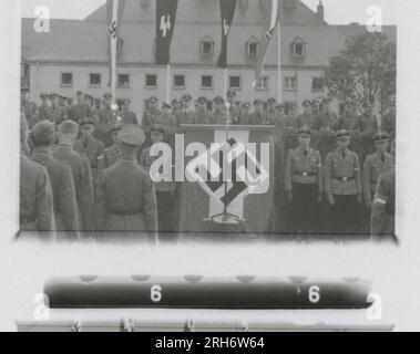 SS Photographer, Heiss (1943) Unit and soldiers in barracks, visit by Himmler with formal ceremony including Hitler Youth, unit movement by rail, soldiers manning an observation post in mountains, patrol in mountainous terrain and field activities, machine gun crew. Stock Photo