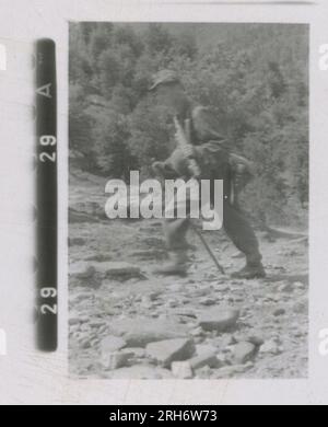 SS Photographer, Heiss (1943) Unit and soldiers in barracks, visit by Himmler with formal ceremony including Hitler Youth, unit movement by rail, soldiers manning an observation post in mountains, patrol in mountainous terrain and field activities, machine gun crew. Stock Photo