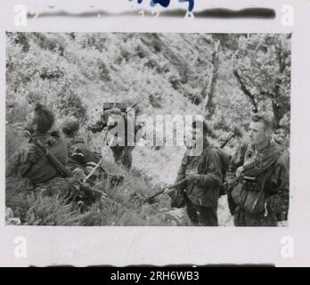 SS Photographer, Heiss (1943) Unit and soldiers in barracks, visit by Himmler with formal ceremony including Hitler Youth, unit movement by rail, soldiers manning an observation post in mountains, patrol in mountainous terrain and field activities, machine gun crew. Stock Photo