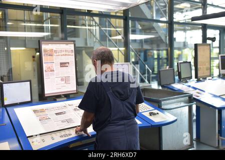 Computer worker in a newspaper printing plant checking the layout Stock Photo