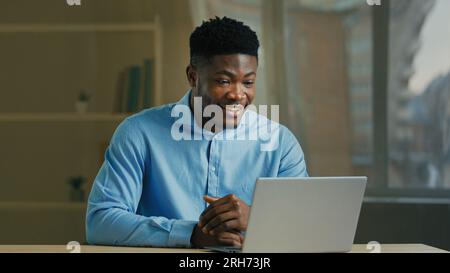 African american businessman has virtual meeting on laptop smiling ethnic man male executive coach tutor talk computer webcam video call remote Stock Photo
