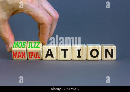 Mobilization or manipulation symbol. Concept words Mobilization Manipulation on wooden cubes. Beautiful grey background. Psychologist hand. Psychology Stock Photo