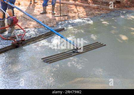 In addition to leveling concrete for driveways, workers use trowel level Stock Photo