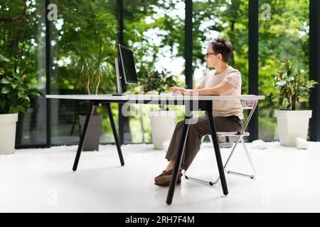 Side view mature woman project manager working at eco-friendly office Stock Photo