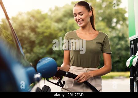 Lady Filling Up Car With Fuel at Modern Gas Station Stock Photo