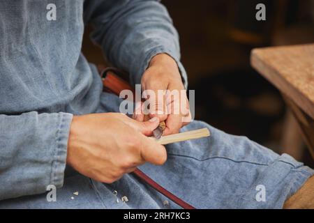 Guy carving wood at viking festival in Denmark. Close-up Stock Photo