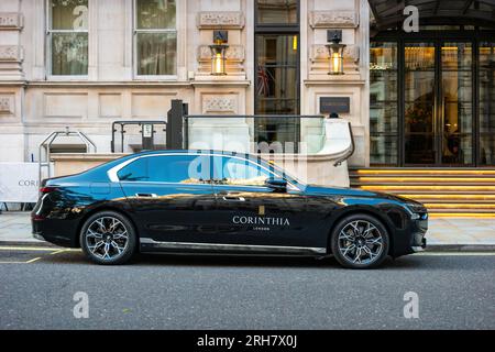 An electric BMW i7 sedan is parked in front of the Corinthia Hotel London in central London England UK. Stock Photo