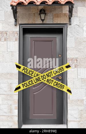 Yellow crime scene tape blocking entrance to house Stock Photo