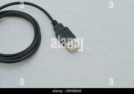 Black USB Type-C cable detail highlighted on a clear surface, perfect for modern technology concepts. Close-up black USB Type-C cable providing speed Stock Photo
