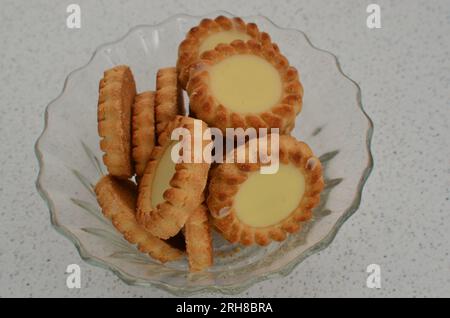 Close-up of delicious biscuits in the form of tartlets filled with white chocolate, an irresistible temptation. Crispy biscuits with generous white ch Stock Photo