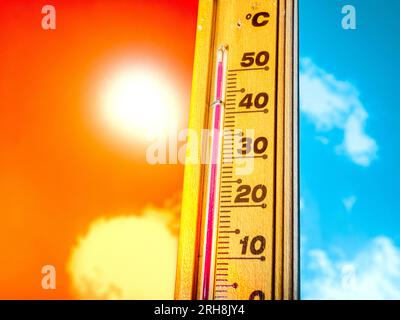 Wooden thermometer with red measuring liquid showing high temperature over  32 degrees Celsius on background of blue sky with clouds. Concept of heat w  Stock Photo - Alamy