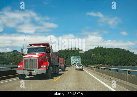Red truck semi truck with trailer driving on highway. Big industrial truck transporting cargo running on highway. Business, commercial, cargo transpor Stock Photo