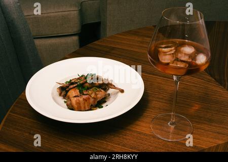 Quail With Grapes (Cailles aux raisins) served with red wine Stock Photo