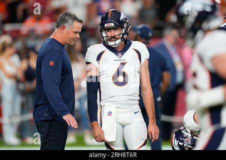 Denver Broncos offensive coordinator Joe Lombardi, left, pauses next to  Broncos quarterback Ben DiNucci (6) prior to an NFL preseason football game  against the Arizona Cardinals, Friday, Aug. 11, 2023, in Glendale