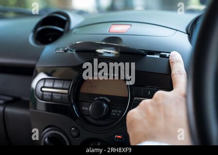 The man pressing eject button on CD player to eject the CD. Car audio system concept. Stock Photo