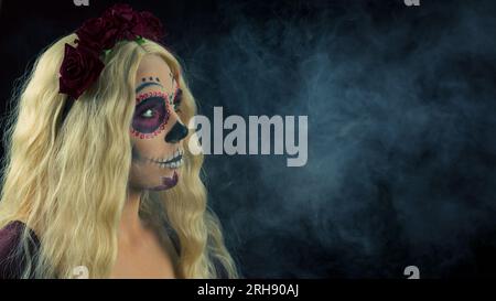 Woman with sugar skull makeup and blond hair isolated on black background. Day of the dead. Halloween.  Copy space. Stock Photo