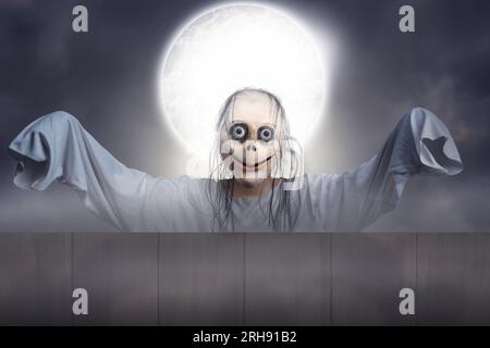 Scary Momo standing behind the wall in the dark background. Scary face for  Halloween. Halloween concept Stock Photo - Alamy