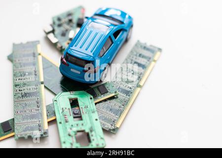 Toy cars on an electronic board with integrated circuits. The shortage of microchips and semiconductors creates a shortage of new cars. semiconductor Stock Photo
