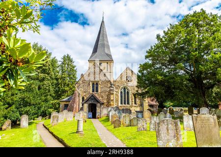 St James's Church and churchyard with headstones in Shere village, Surrey, England Stock Photo