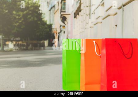 three colourful paper shopping bags on street Stock Photo
