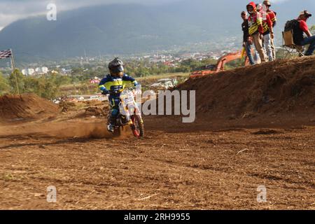 The style and action of the motorcycle racers and the enthusiasm of the spectators crowding the circuit Stock Photo