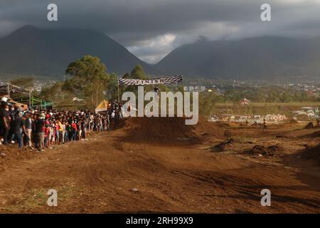 The style and action of the motorcycle racers and the enthusiasm of the spectators crowding the circuit Stock Photo