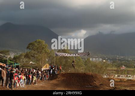 The style and action of the motorcycle racers and the enthusiasm of the spectators crowding the circuit Stock Photo