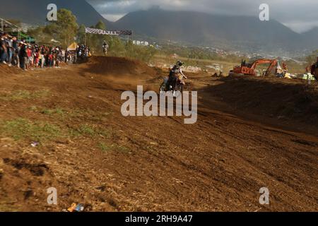 The style and action of the motorcycle racers and the enthusiasm of the spectators crowding the circuit Stock Photo