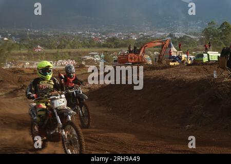 The style and action of the motorcycle racers and the enthusiasm of the spectators crowding the circuit Stock Photo