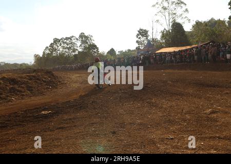 The style and action of the motorcycle racers and the enthusiasm of the spectators crowding the circuit Stock Photo