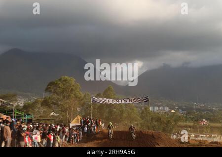 The style and action of the motorcycle racers and the enthusiasm of the spectators crowding the circuit Stock Photo