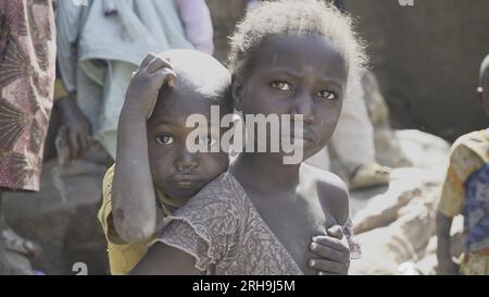 beautiful picture of an African sister holding her younger brother on her back. resembling the deep-rooted sense of care in our human nature. poverty. Stock Photo