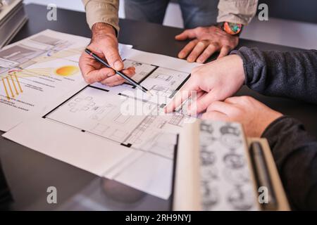 group of engineers meeting in boardroom team leader man presenting ideas on whiteboard discussing strategy with colleagues in office. blue print. Stock Photo
