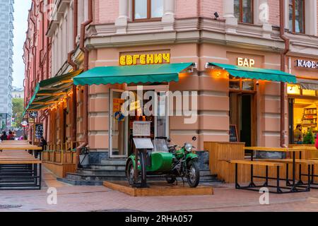 An old green vintage soviet motorcycle with a sidecar in front of a restaurant on a city street. Moscow. Russia. August 13, 2023. Stock Photo