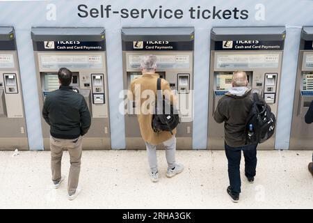 File photo dated 3/3/2023 of people using a ticket machine at Waterloo train station in London. Next year's rise in English rail fares will be below inflation, the Government has announced. The Department for Transport (DfT) said the increase will not be as high as the rise in the Retail Prices Index (RPI) for the 12 months to July. Issue date: Tuesday August 15, 2023. Stock Photo
