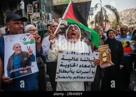 Nablus, Palestine. 15th Aug, 2023. A Palestinian protester with a flag chants slogans during the demonstration in solidarity with Palestinian prisoners detained by the Israeli occupation, in the city of Nablus in the occupied West Bank. Credit: SOPA Images Limited/Alamy Live News Stock Photo