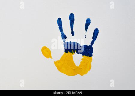 Yellow-blue human palm print on a white canvas (close-up). National symbols of Ukraine Stock Photo