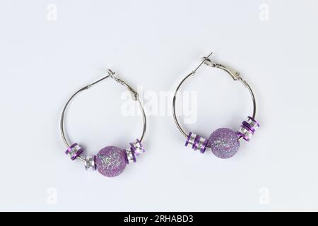 Purple earring isolated on white background. Stock Photo