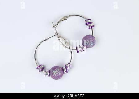 Purple earring isolated on white background. Stock Photo