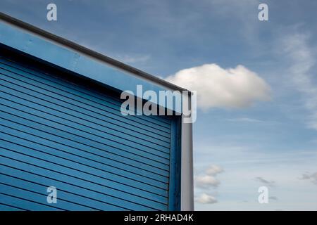industrial estate construction warehouse unit with roller door against a blue sky Stock Photo