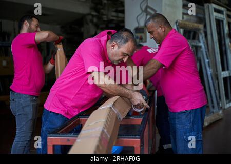 Workers packing cardboard box in warehouse for shipment.  an operator closes a cardboard box with adhesive tape in a warehouse. Stock Photo