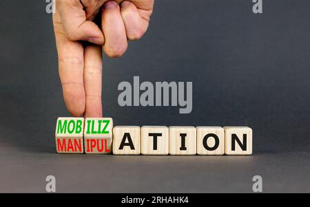 Mobilization or manipulation symbol. Concept words Mobilization Manipulation on wooden cubes. Beautiful grey background. Psychologist hand. Psychology Stock Photo