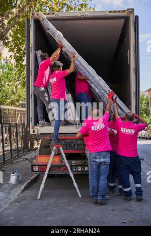 Workers packaging glass sheets in warehouse. worker shipping glass window. worker wearing safety vest and helmet. Stock Photo