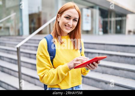 Young caucasian woman student smiling confident using touchpad at university Stock Photo