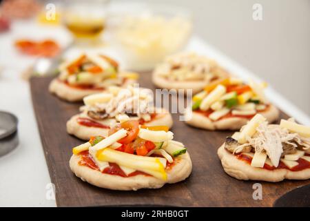 Ready to be baked mini pizzas. Delicious home made mini pizzas preparation. Stock Photo