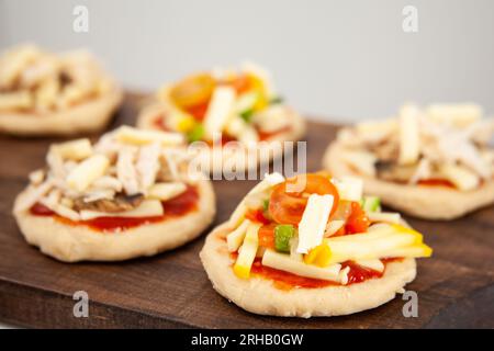 Ready to be baked mini pizzas. Delicious home made mini pizzas preparation. Stock Photo
