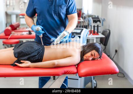 Extracorporeal shockwave therapy, physical therapy for neck and back muscles. Stock Photo