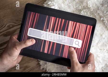 Digital tablet with internet browser search bar on screen in male hands. Stock Photo