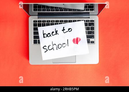 Laptop and a piece of paper with the inscription Back to school. Stock Photo