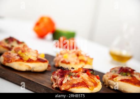 Delicious just baked homemade mini pizzas. Salami pizza. Stock Photo